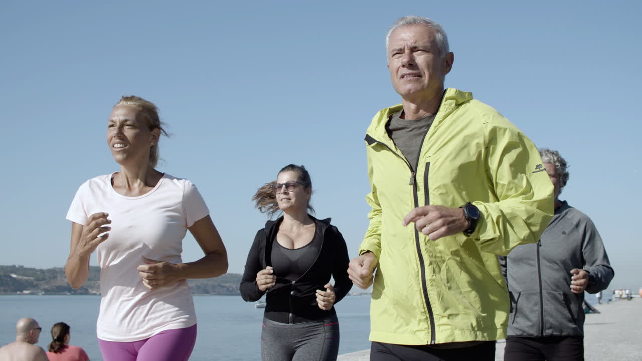 Vídeo Gratis - Viejos corredores activos corriendo en el paseo marítimo