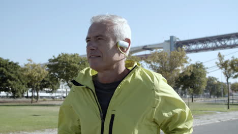 Active-old-jogger-with-headphones-running-outside