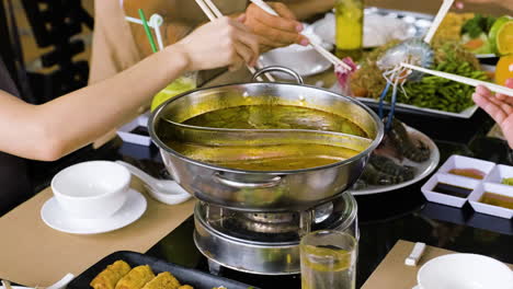 Family-eating-hot-pot-with-seafood-at-the-restaurant