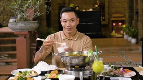 Cheerful-chinese-man-eating-hot-soup-with-noodles