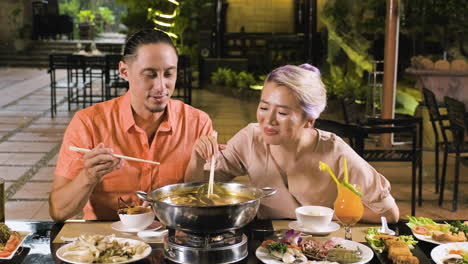Happy-couple-eating-from-chinese-hot-pot-at-the-restaurant