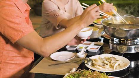 Family-taking-food-from-hot-pot