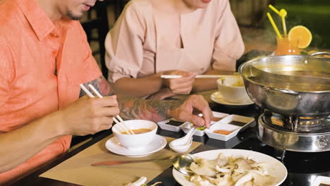 Hombre-Y-Mujer-Asiáticos-Comiendo-Y-Hablando-En-El-Restaurante