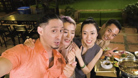 Young-chinese-man-fooling-his-friends-with-a-video-instead-of-a-photo