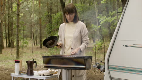 Mujer-Cocinando-En-La-Barbacoa-En-El-Camping-En-El-Bosque