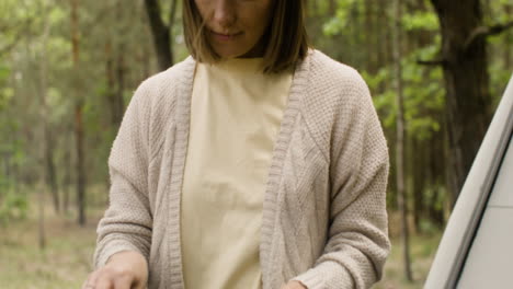 Woman-cooking-on-the-barbecue-at-the-camping-in-the-forest