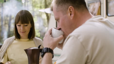 Glückliche-Eltern,-Die-Kaffee-Trinken,-Während-Sie-Mit-Ihren-Kleinen-Söhnen-Auf-Dem-Campingplatz-Im-Wald-Frühstücken