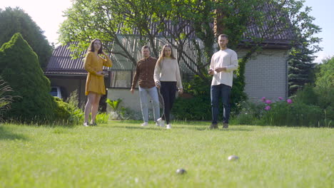 Distant-view-of-four-caucasian-friends-playing-petanque-in-the-park-on-a-sunny-day