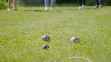 Side-view-of-pentanque-balls-on-the-grass-in-the-park