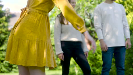 Front-view-of-caucasian-young-woman-hand-throwing-a-petanque-ball-in-the-park-on-a-sunny-day
