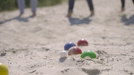 Close-up-view-of-colorful-petanque-balls-on-the-sand-on-the-beach