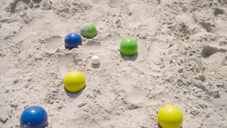 Top-view-of-some-colorful-petanque-balls-on-the-beach-on-a-sunny-day