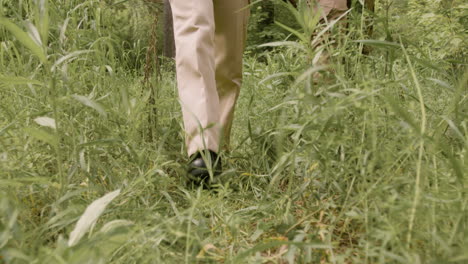 Close-up-view-of-the-feet-of-forest-warden-in-boots-walking-in-the-woods