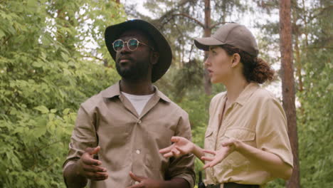 Caucasian-and-african-american-forest-wardens-talking-in-the-woods