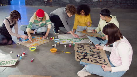 Jóvenes-Activistas-Ambientales-Pintando-Carteles-Sentados-En-El-Suelo
