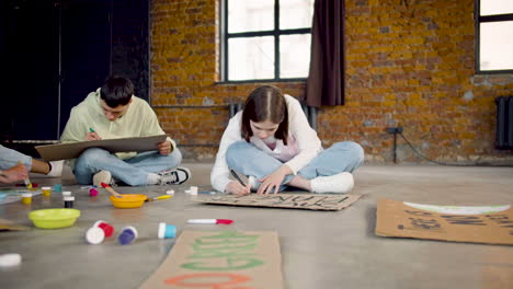 Jóvenes-Activistas-Ambientales-Pintando-Carteles-Sentados-En-El-Suelo