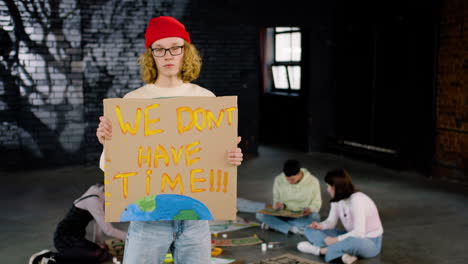 Joven-Activista-Medioambiental-Serio-Sosteniendo-Un-Cartón-Con-La-Inscripción-&quot;no-Tenemos-Tiempo&quot;-Y-Mirando-La-Cámara
