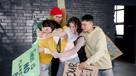 Jóvenes-Activistas-Ambientales-Felices-Con-Pancartas-Y-Megáfonos-Abrazándose-Y-Vitoreando-Después-De-La-Protesta-Por-El-Cambio-Climático