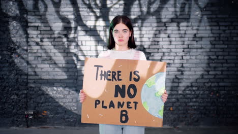 Joven-Activista-Medioambiental-Serio-Sosteniendo-Un-Cartón-Con-La-Inscripción-&quot;no-Hay-Planeta-B&quot;-Y-Mirando-La-Cámara