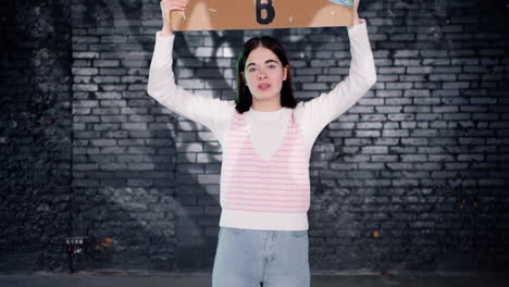 Serious-young-environmental-protester-holding-a-cardboard-with-There-is-no-planet-B"-inscription-and-protesting-while-looking-at-the-camera"