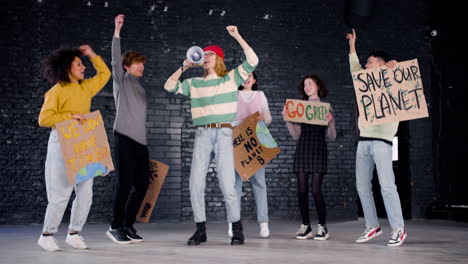 Jóvenes-Activistas-Ambientales-Felices-Con-Pancartas-Y-Megáfonos-Saltando-Y-Abrazándose-Mientras-Protestan-Contra-La-Inacción-Del-Cambio-Climático