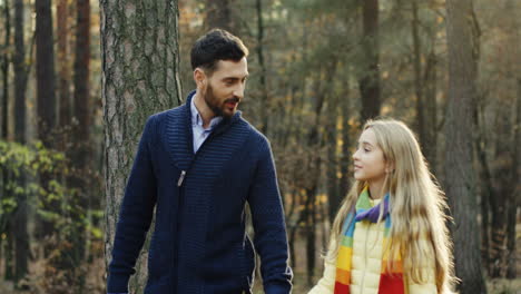 Caucasian-happy-father-and-his-daughter-walking-and-talking-in-the-forest