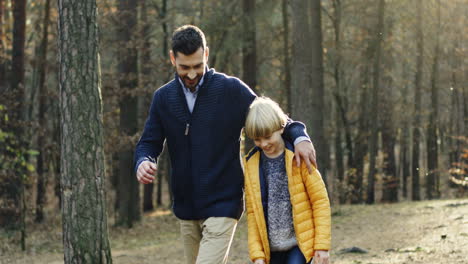 Caucasian-happy-father-and-his-little-son-walking-and-talking-in-the-forest