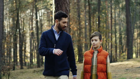 Caucasian-happy-father-and-his-little-son-walking-and-talking-in-the-forest