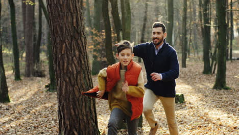 Caucasian-happy-father-with-his-little-son-running-and-playing-in-the-forest