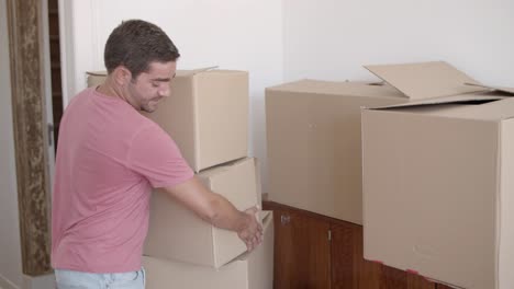 Young-guy-coming-into-new-house-or-apartment-for-the-first-time