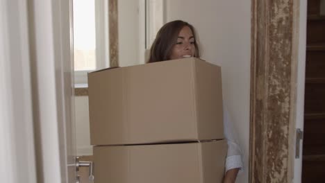 Young-woman-putting-two-boxes-on-another-one