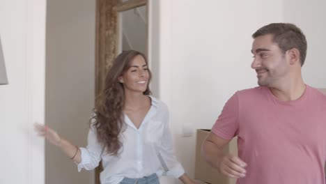 Young-Caucasian-couple-coming-into-new-apartment-for-the-first-time