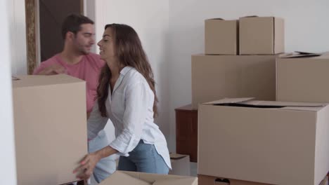 Happy-man-giving-cardboard-boxes-to-girlfriend-who-putting-them-on-the-table