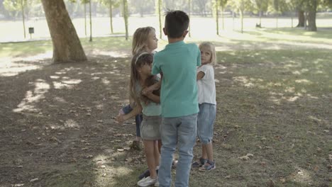 Happy-children-standing,-holding-hands-and-playing-game-in-the-park
