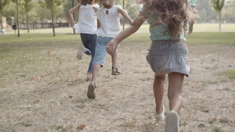 Back-view-of-children-running-and-competing-in-speed-in-the-park