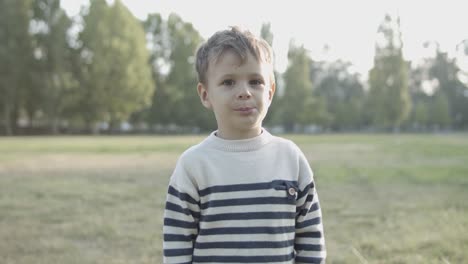 Porträt-Eines-Süßen-Kaukasischen-Jungen,-Der-Im-Park-Steht-Und-Für-Die-Kamera-Posiert