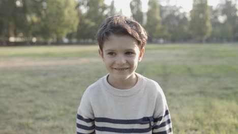 Porträt-Eines-Süßen-Kaukasischen-Jungen,-Der-Beim-Lächeln-Springt-Und-Die-Kamera-Im-Park-Anschaut