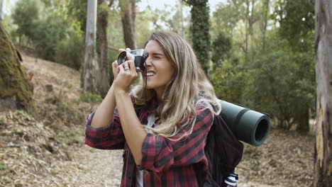 Active-tourist-girl-with-photo-camera-taking-pictures-of-forest