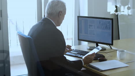 Focused-mature-male-trader-working-with-the-computer