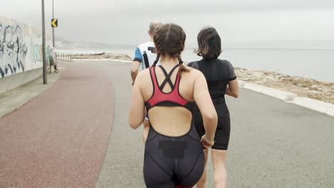 Grupo-De-Triatletas-Entrenando-Para-Maratón-En-El-Paseo-Marítimo