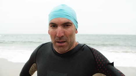 Serious-male-swimmer-looking-at-camera-at-the-beach