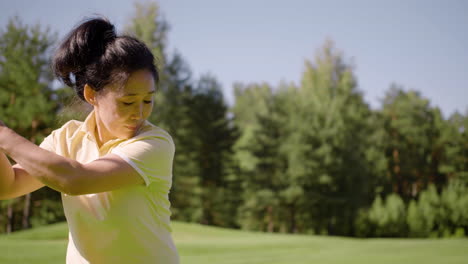 Asian-woman-in-yellow-outfit-playing-golf