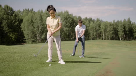 Asian-people-practicing-and-hitting-golf-balls-on-field