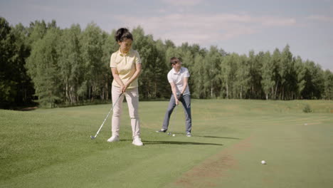 Golfspieler-Mit-Golfschlägern-Auf-Rasenfläche,-In-Der-Nähe-Von-Wäldern