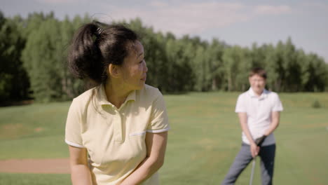 Pareja-Asiática-Hablando-Y-Practicando-Golf