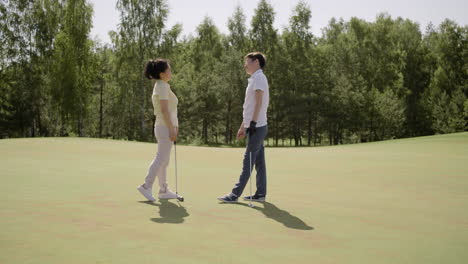 Jugadores-De-Golf-Hablando-Y-Chocando-Los-Cinco-En-El-Campo-De-Hierba