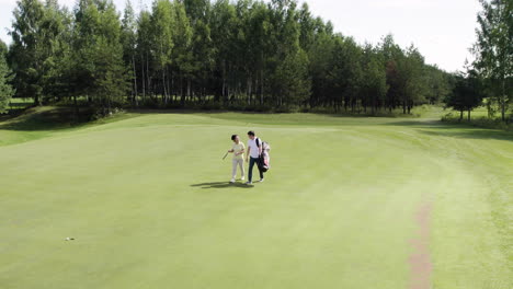Jugadores-De-Golf-Asiáticos-Hablando-Y-Caminando-Por-El-Campo-De-Golf