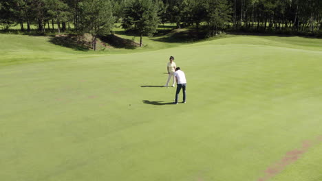 Mature-couple-playing-golf-on-field-on-a-sunny-day