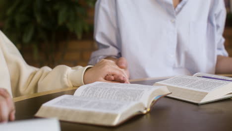 Closeup-of-the-Bible-book-on-the-table-while-the-teacher-and-the-students-are-praying
