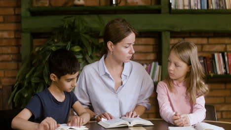 Young-kids-and-teacher-reading-the-Bible-book-and-praying